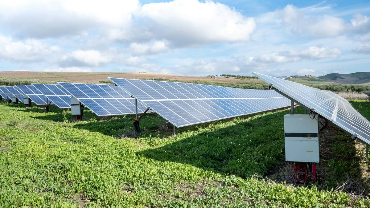 Power solar panels benefits shown on a flat commercial roof with inverters and metering hardware visible